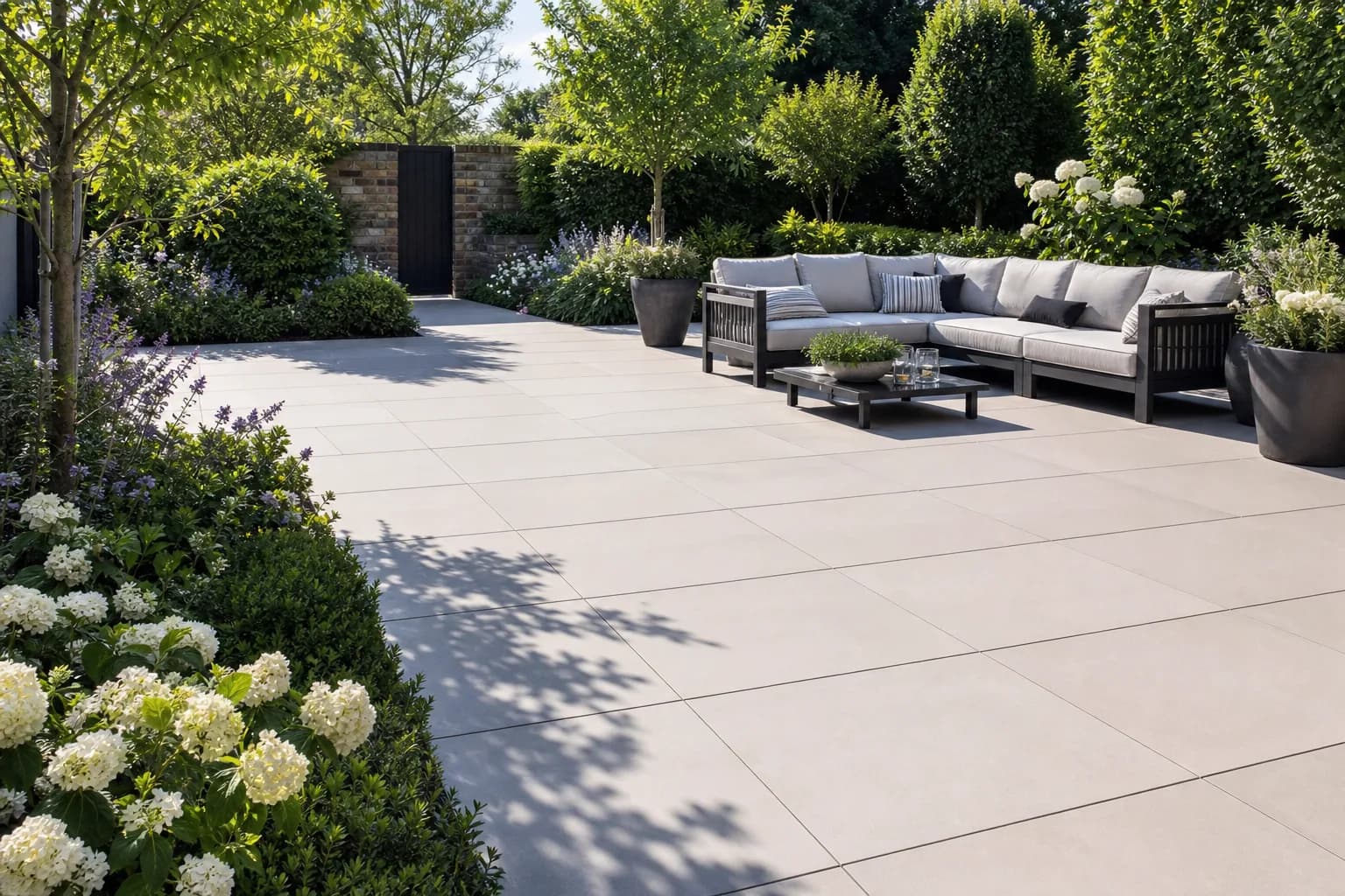 Large porcelain paved patio with clean joints in a landscaped garden