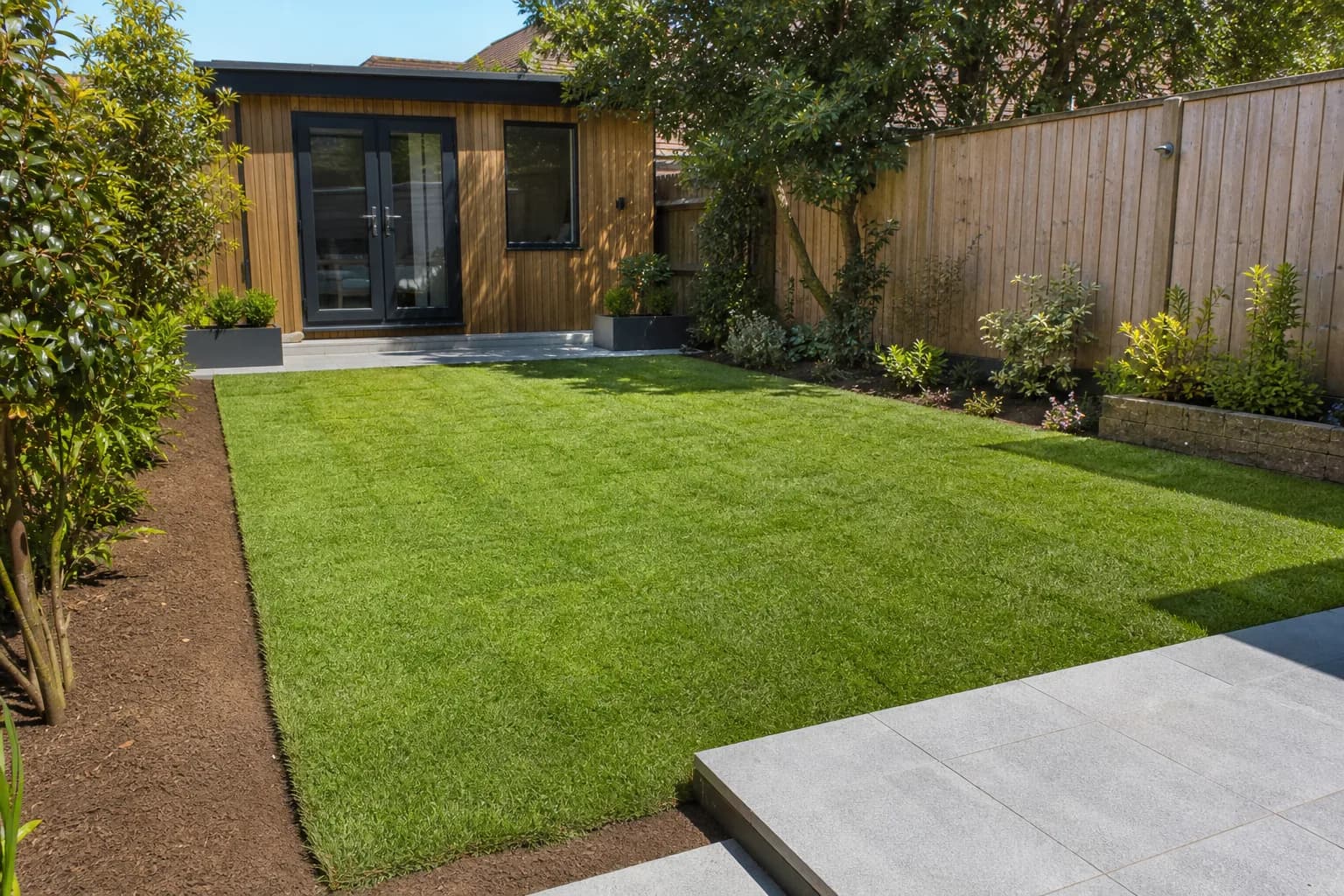 Freshly laid green turf lawn on prepared soil in a back garden